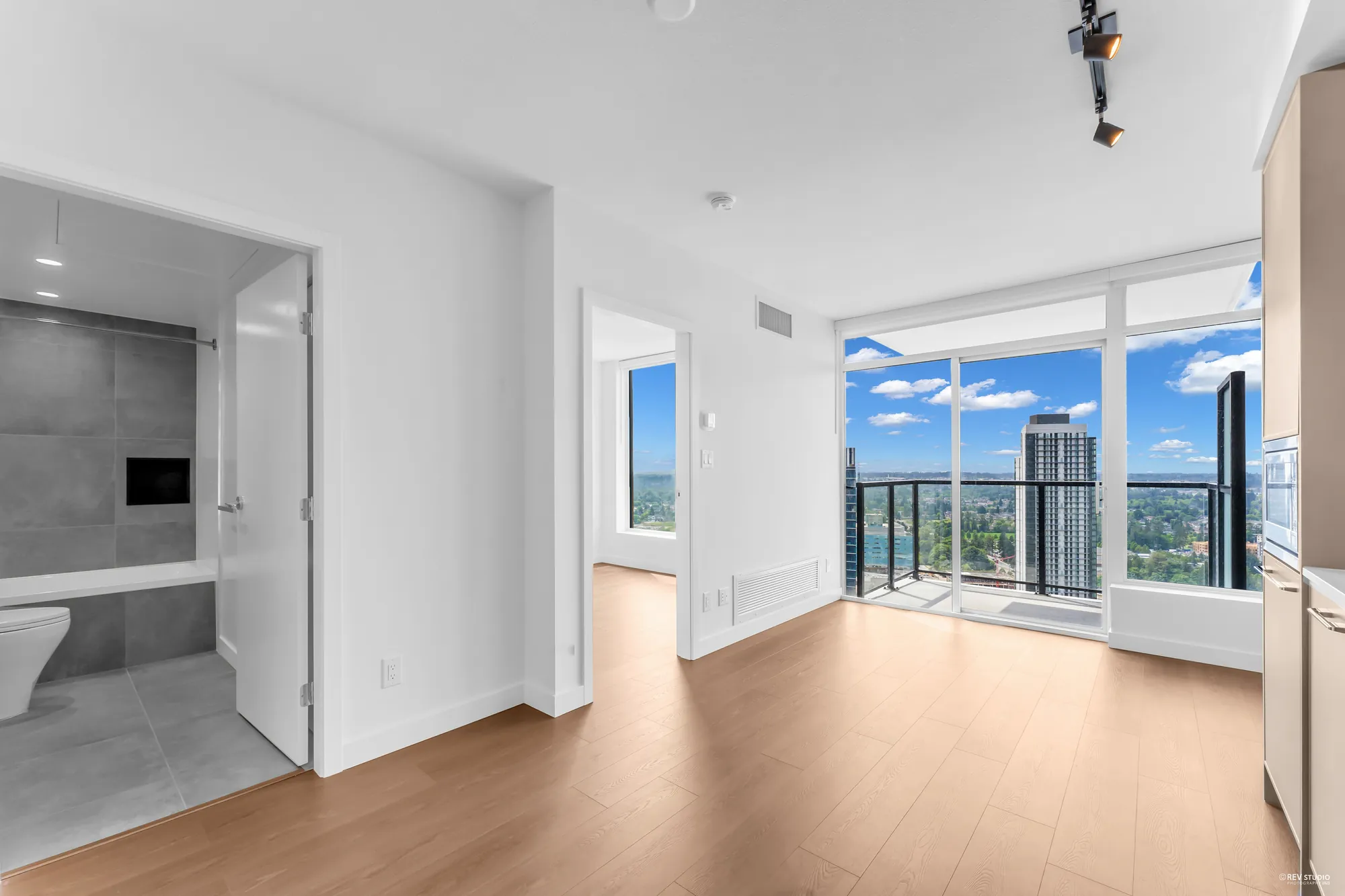 From the kitchen toward the windows, bathroom door open at left