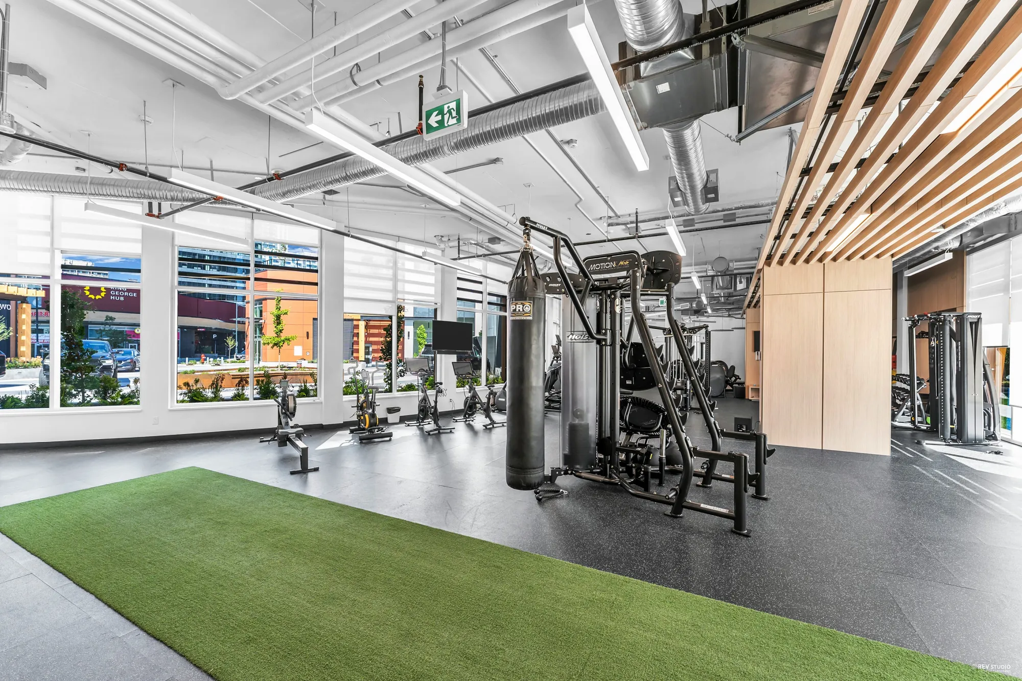 The fitness hub: weights, bags and cardio under a timber ceiling