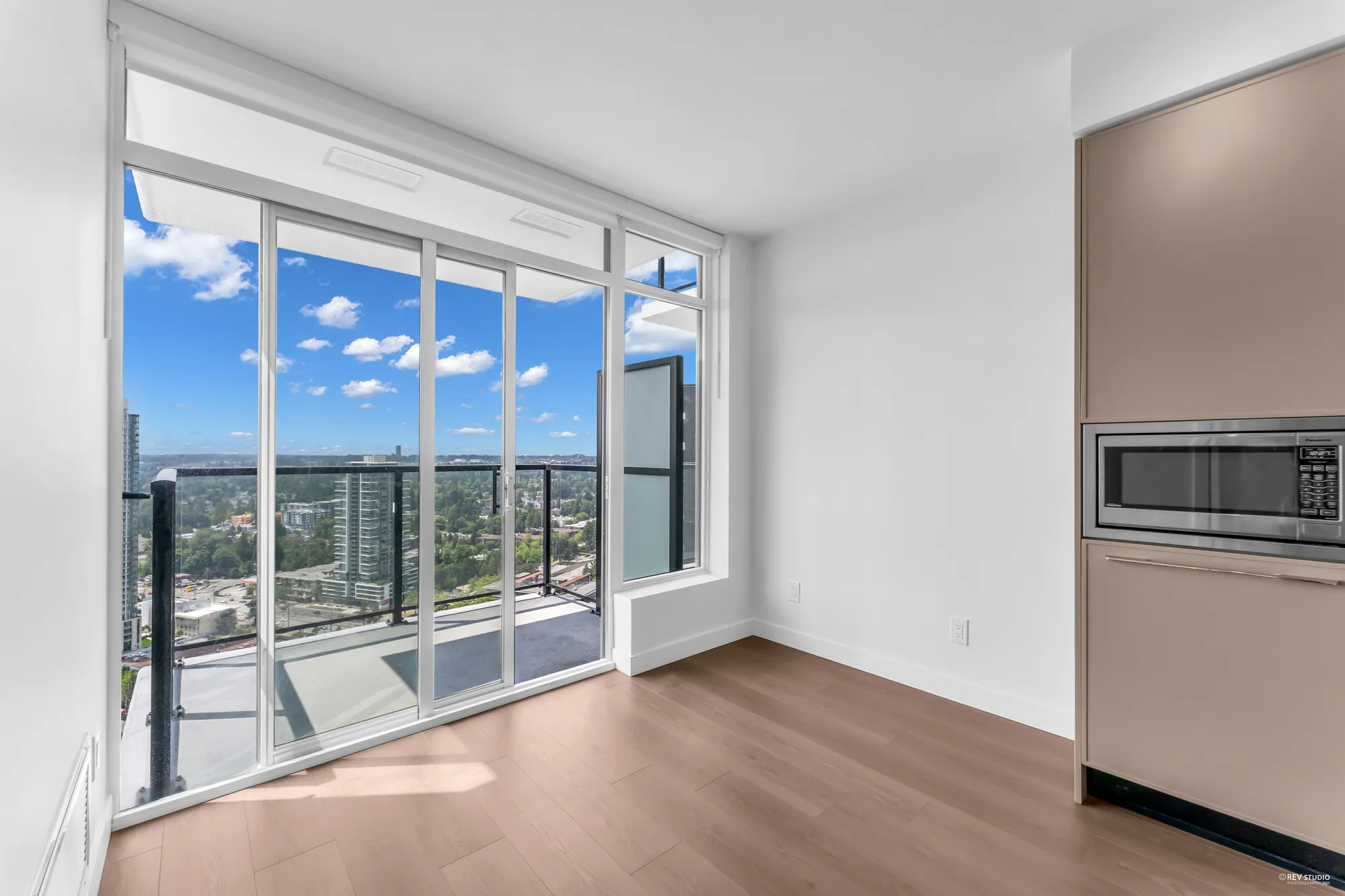The window wall from the living room corner, kitchen at right