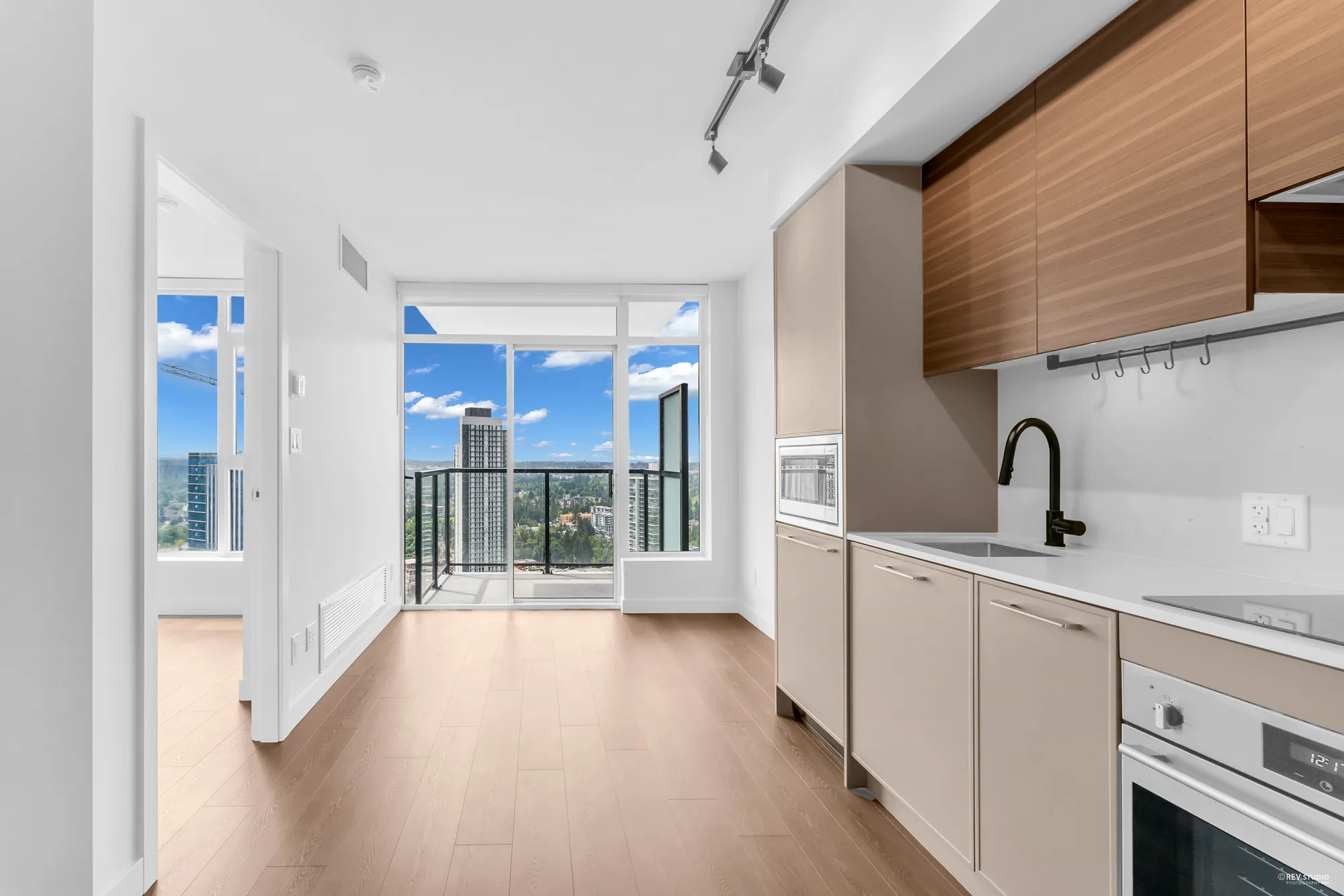 Sink and oven beside the window wall, balcony beyond