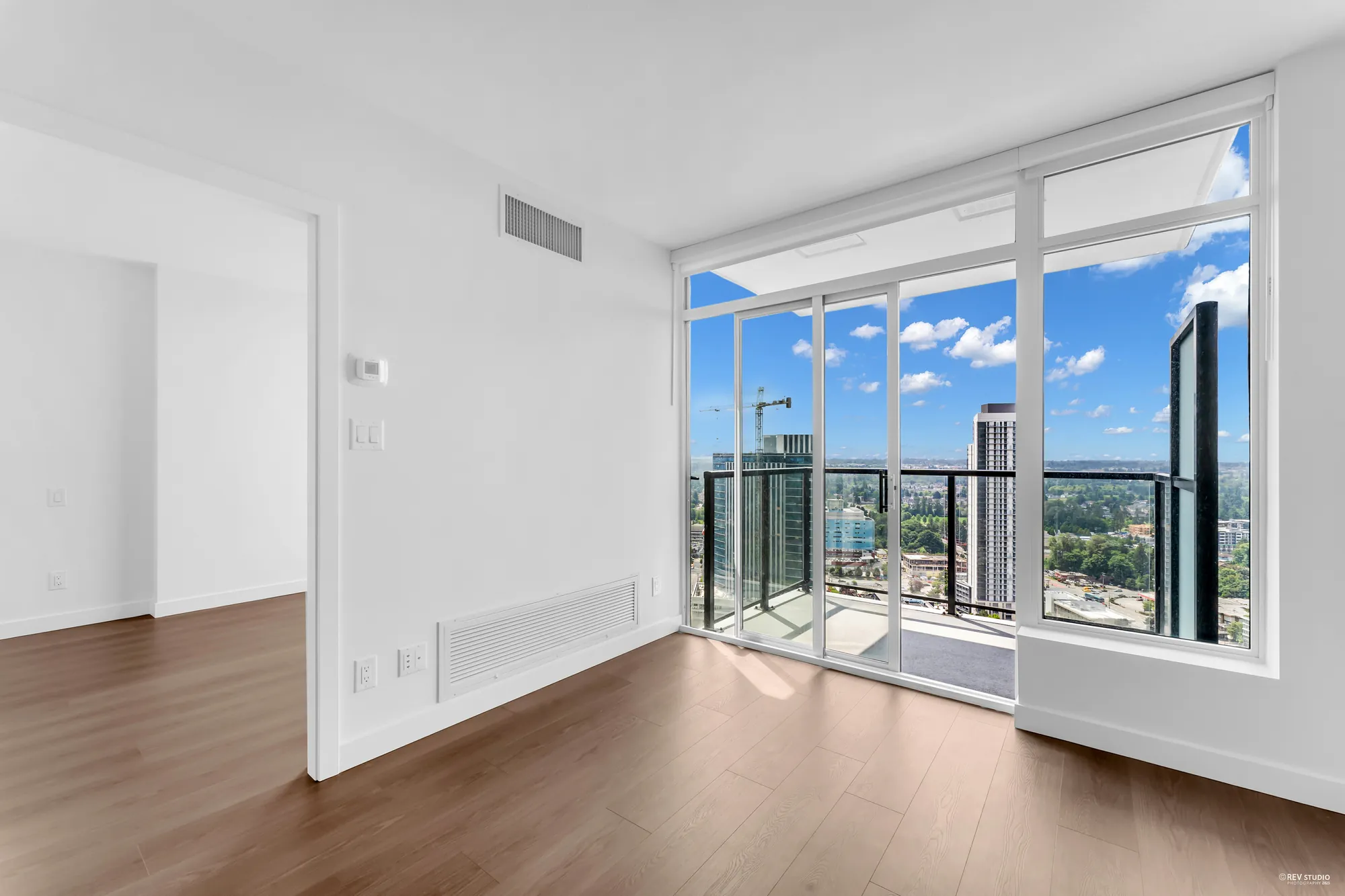 The living room window wall and balcony door