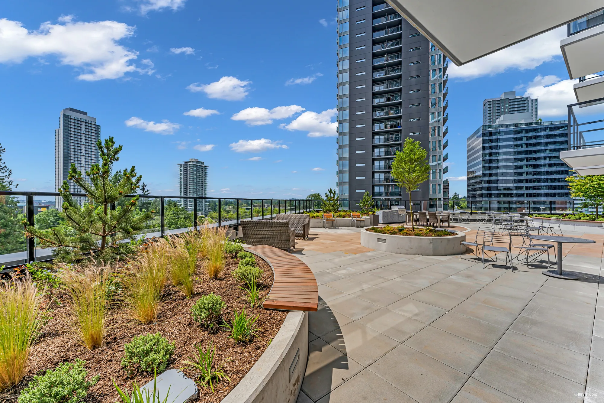 The rooftop terrace: planters, benches and the neighbouring towers